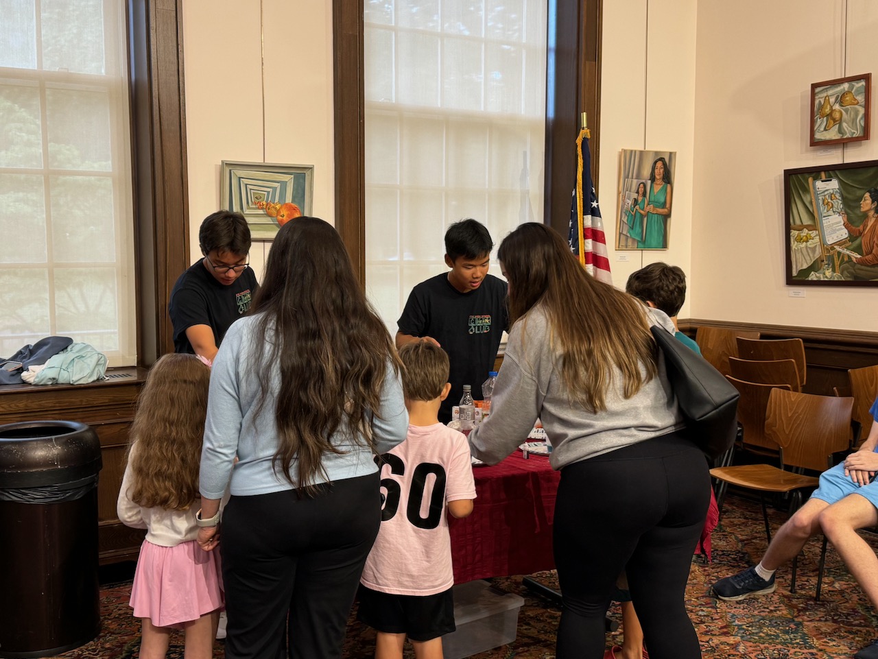 Children and adults gathered around a Chemistry Day activity table at Rye Library.