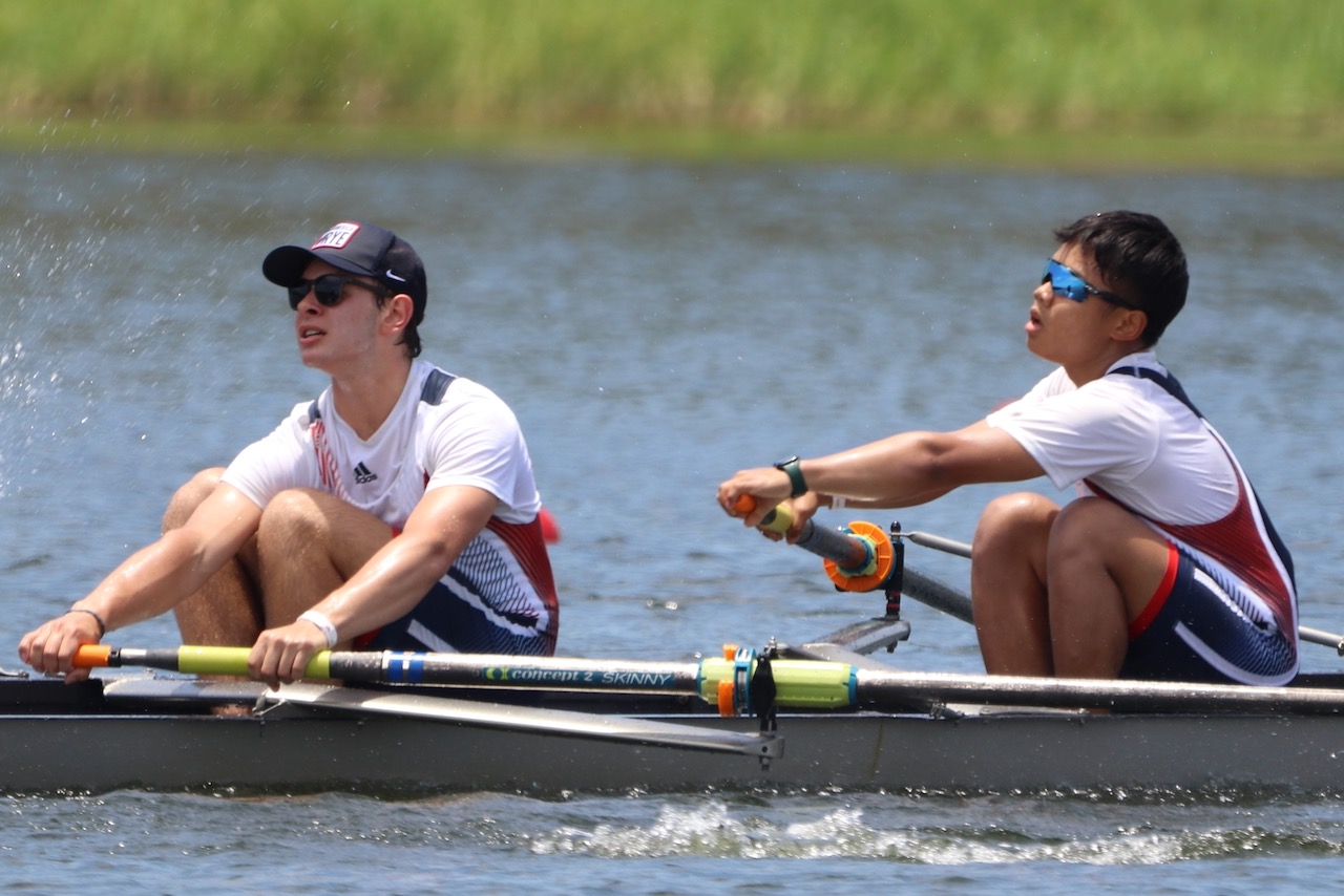 A close-up of two RowAmerica Rye teammates pulling their oars through a stroke.