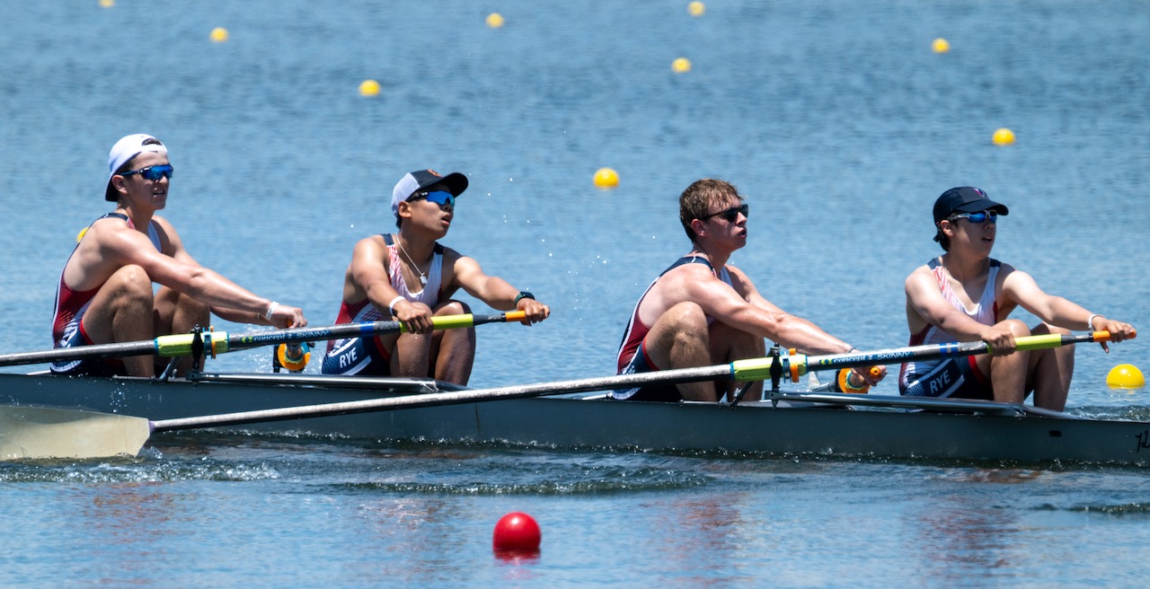 Four teammates moving through a stroke together during a race.